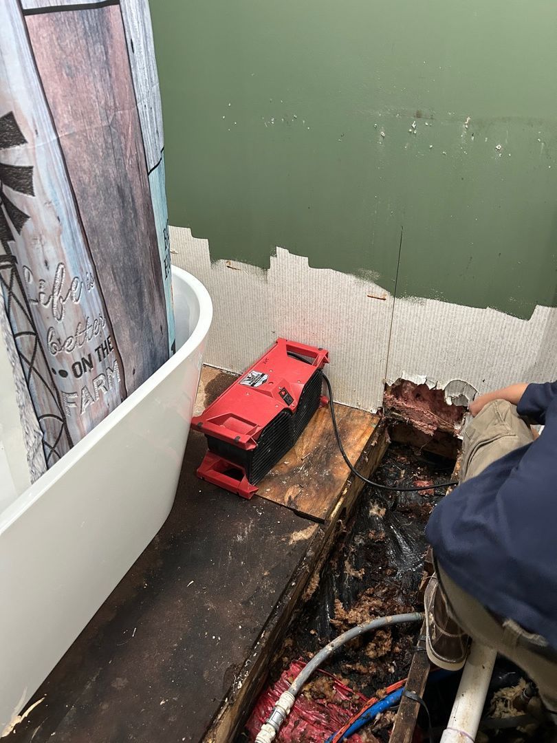 Exposed subfloor showing water damage and discoloration in Hartville bathroom