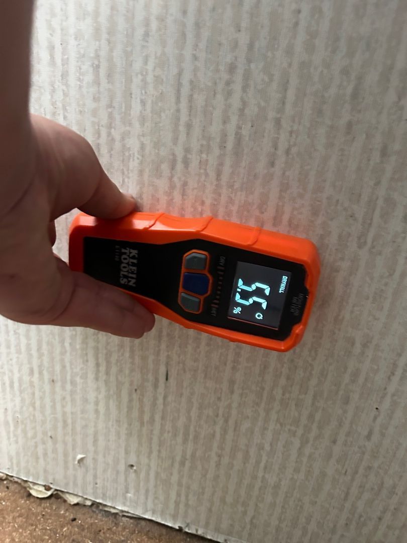 Moisture meter showing 52 percent reading on bathroom wall near plumbing in Hartville home