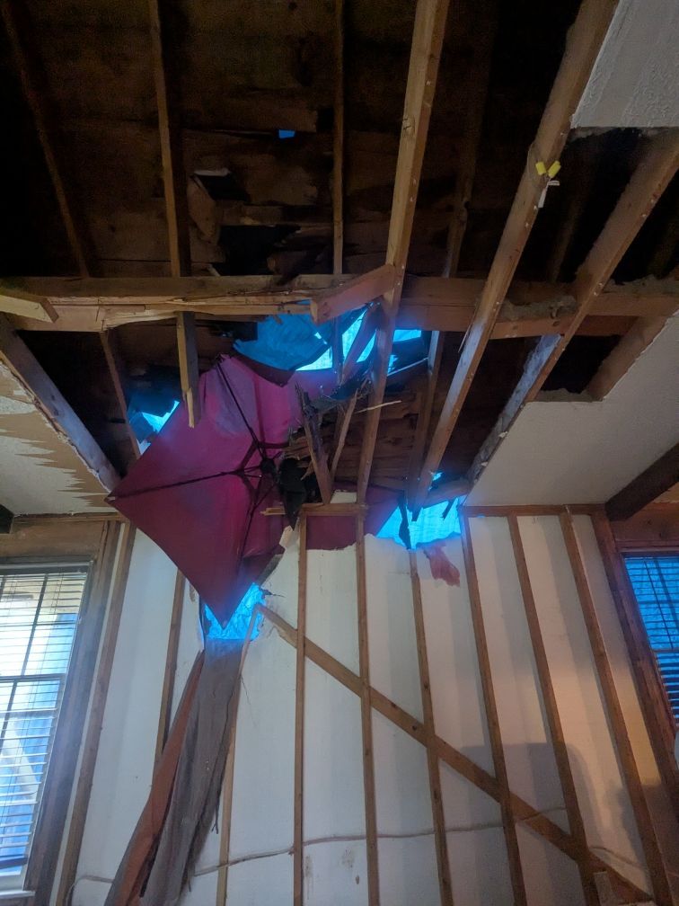 Ceiling collapse from fallen tree impact showing exposed framing and debris