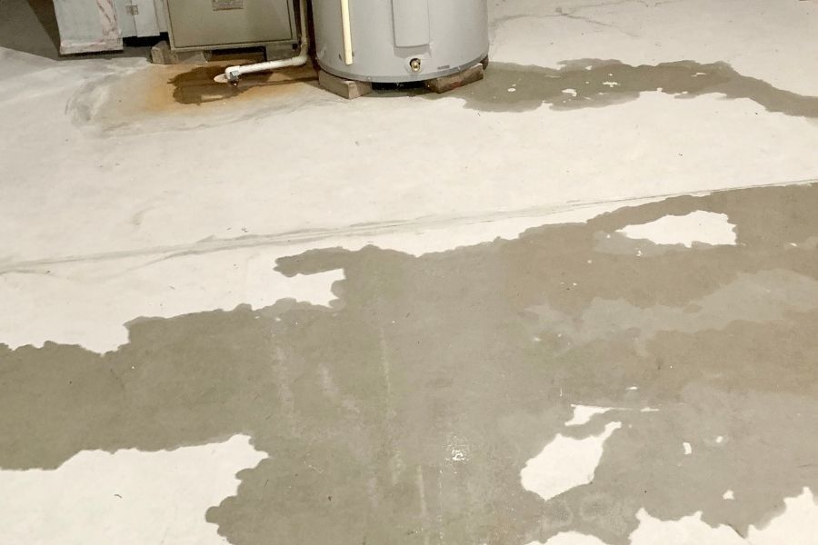 Flooded basement floor with standing water showing significant water intrusion