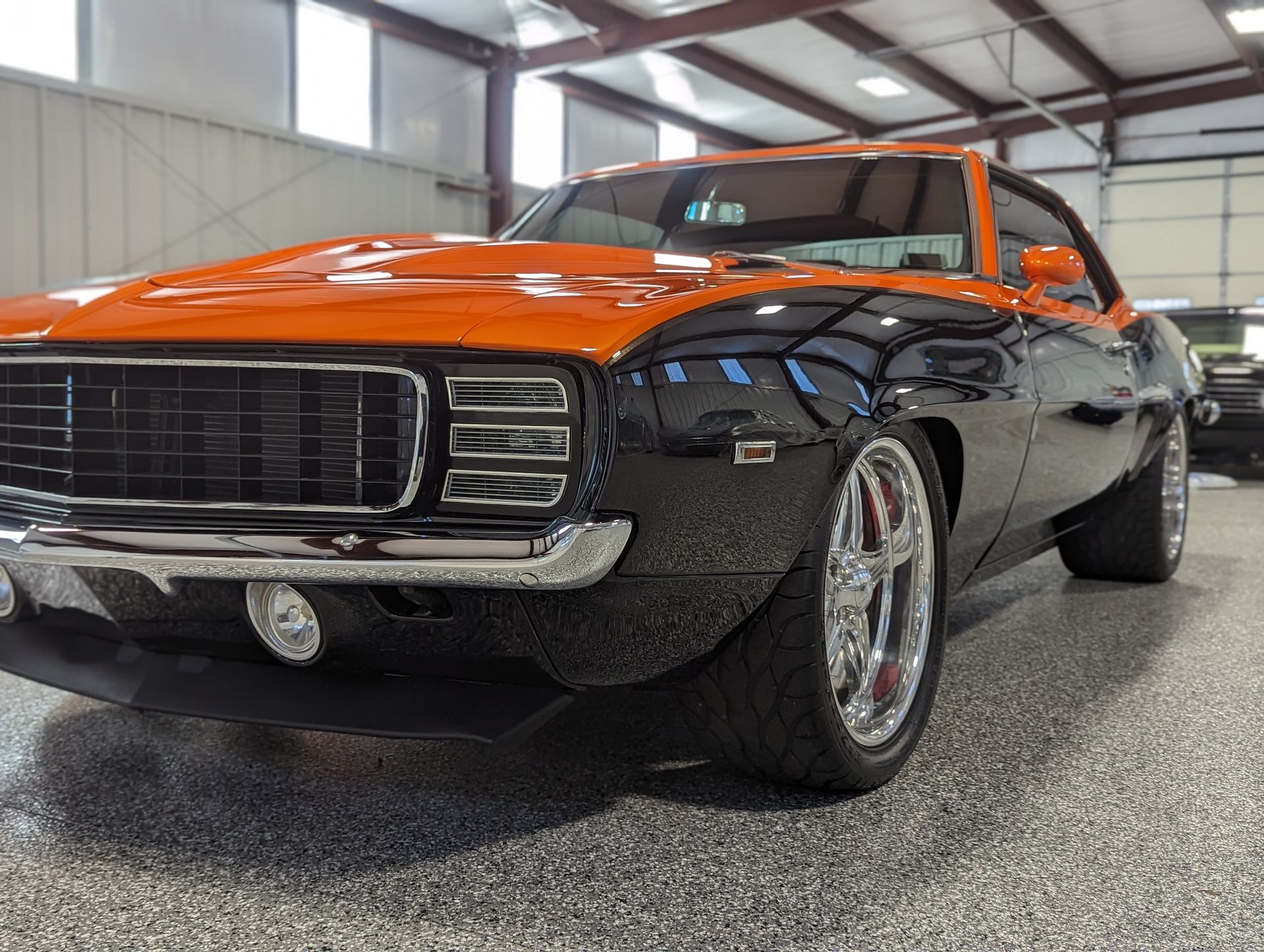 A black and orange car is parked in a garage