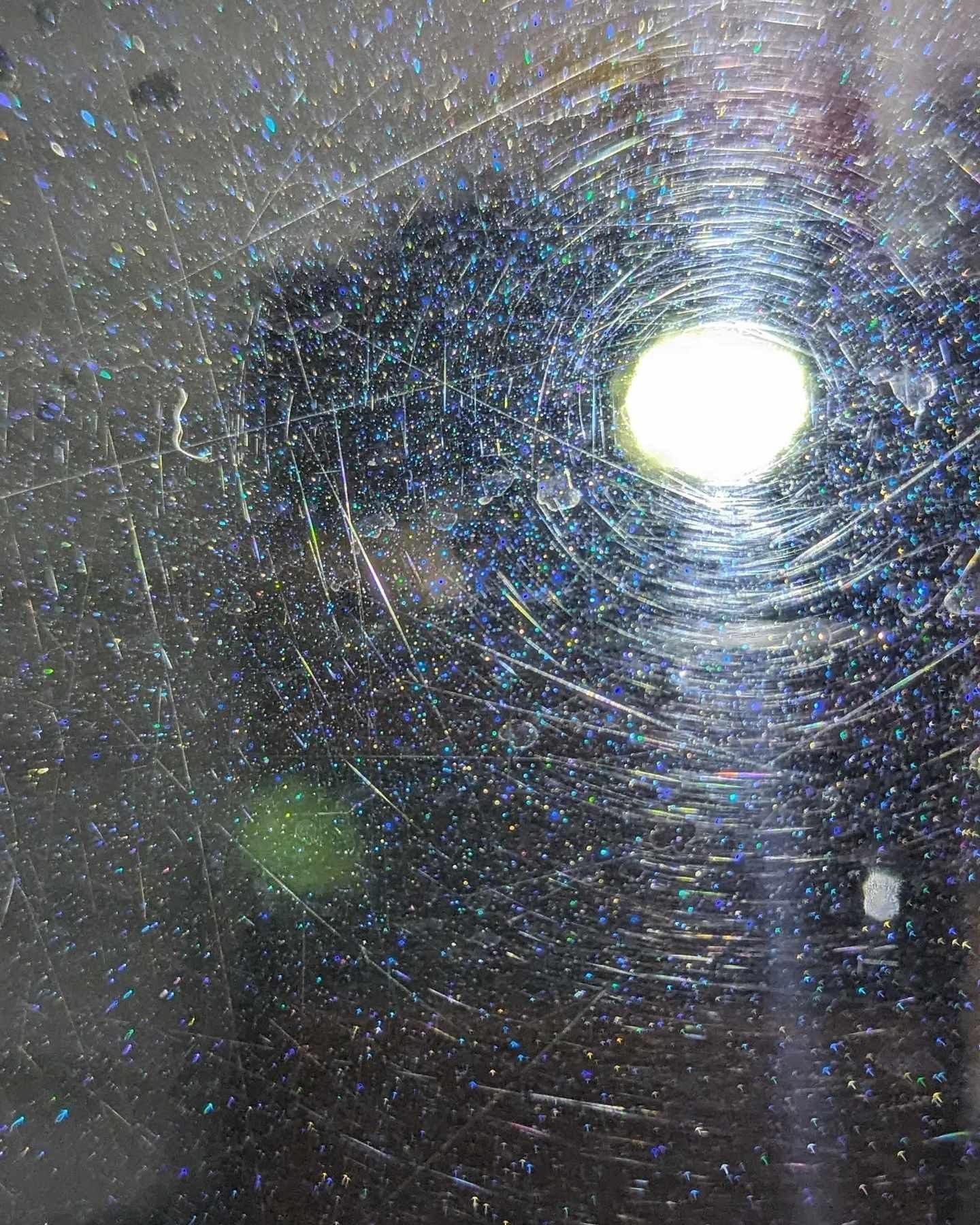 A close up of a spider web with a light shining through it.