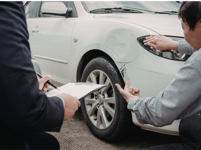 Two individuals examining a scratched car and discussing repairs with support from a home and auto insurance broker service in San Tan Valley, AZ