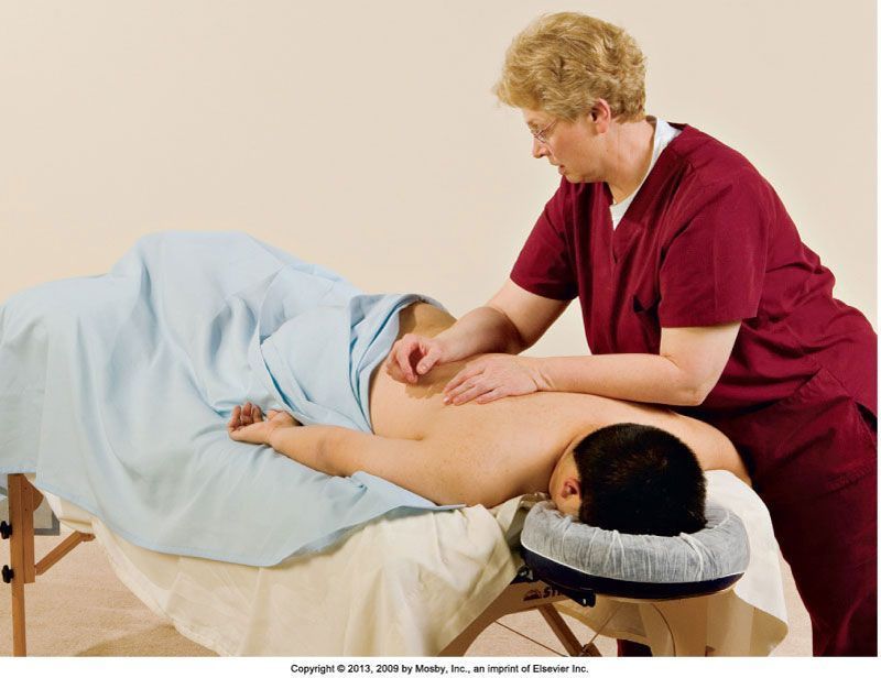 A woman is giving a man a massage on a table