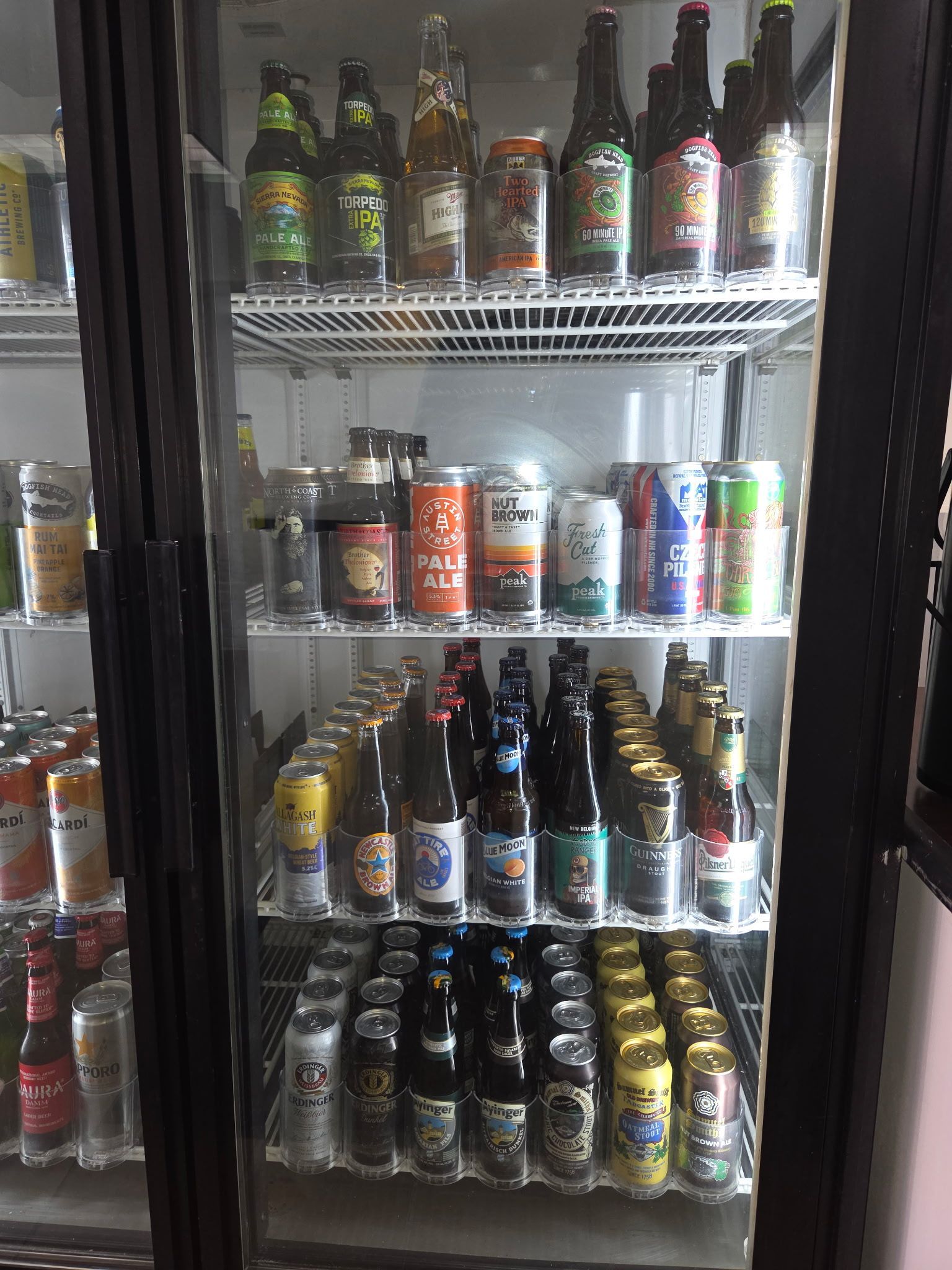 A refrigerator stocked with various bottles and cans of beer.