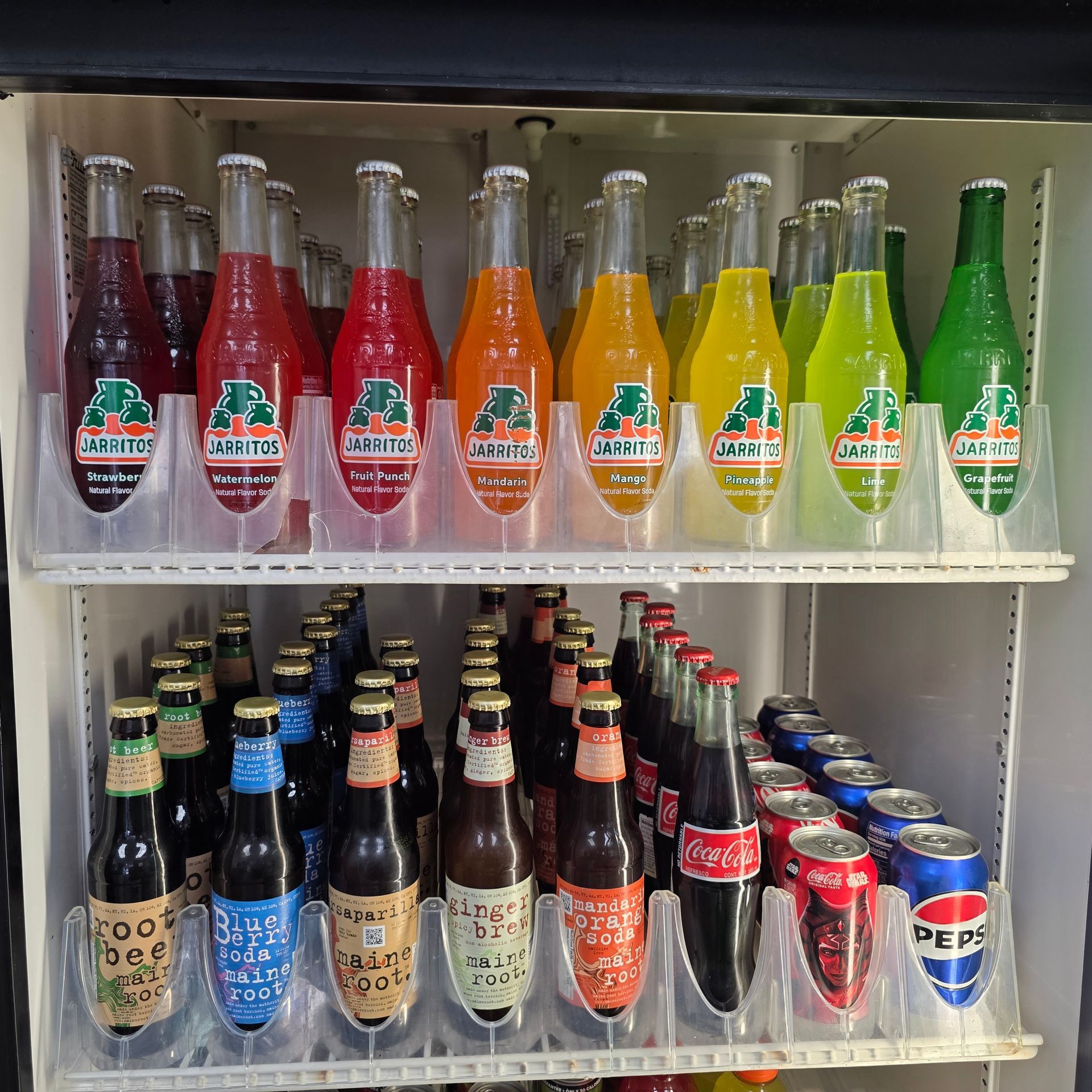 Red Coca-Cola can with splashing water, against a black background.