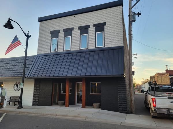 A white truck is parked in front of a building