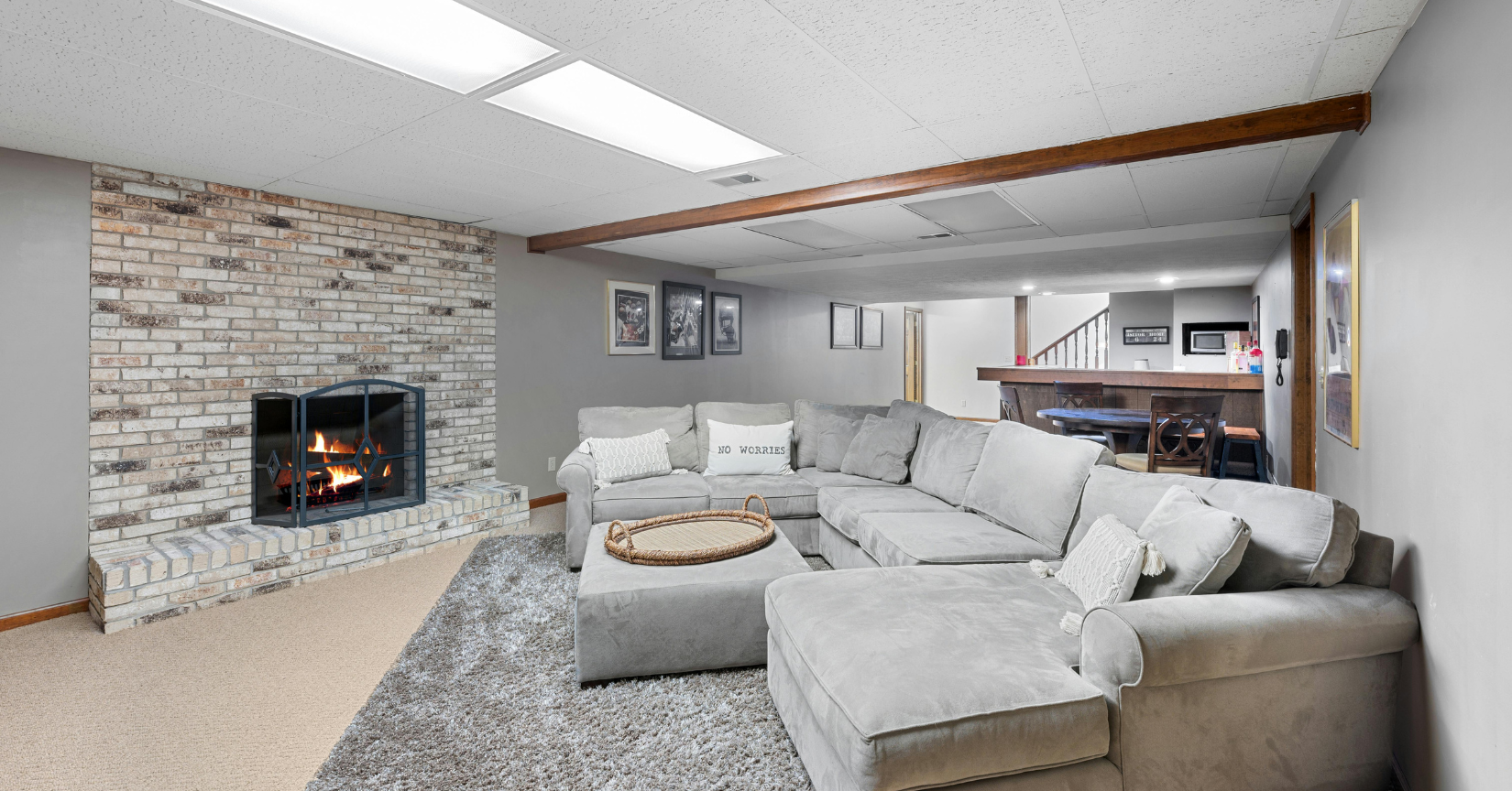 A living room with a large sectional couch and a fireplace.