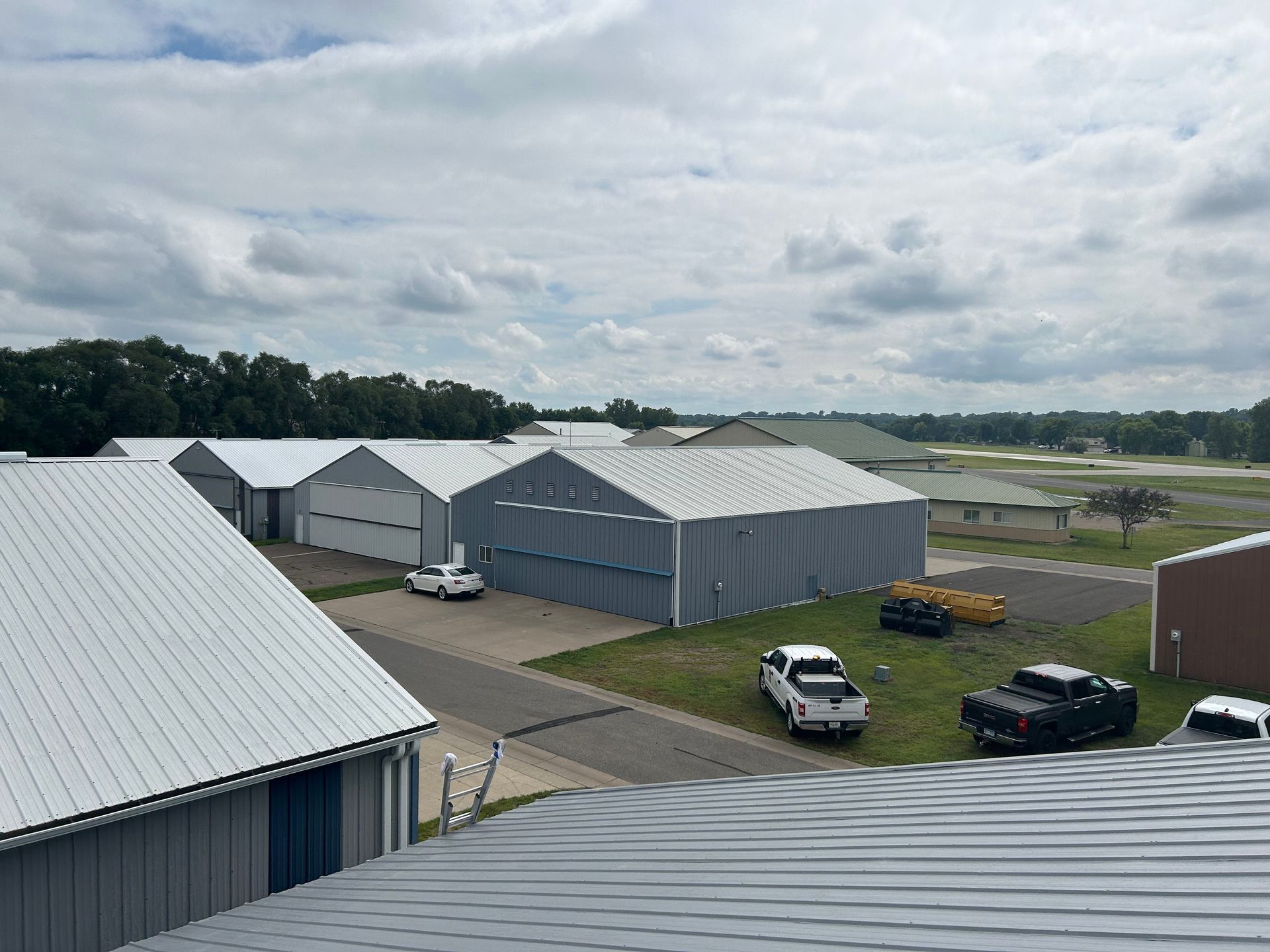 A group of buildings with trucks parked in front of them on a cloudy day.