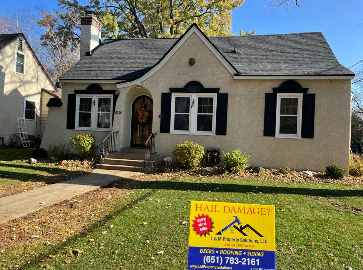 A house with a roof damage sign in front of it.