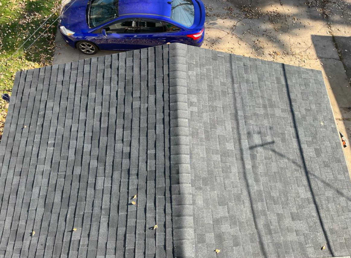 A blue car is parked on the roof of a house.