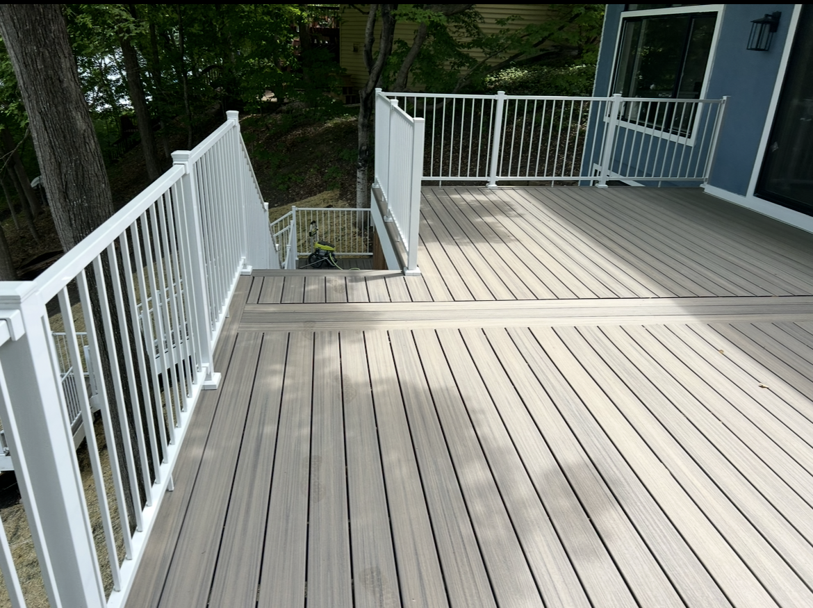 A deck with a white railing and stairs leading up to it