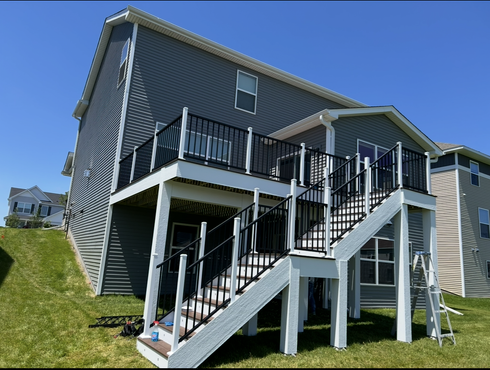 The back of a house with a deck and stairs.