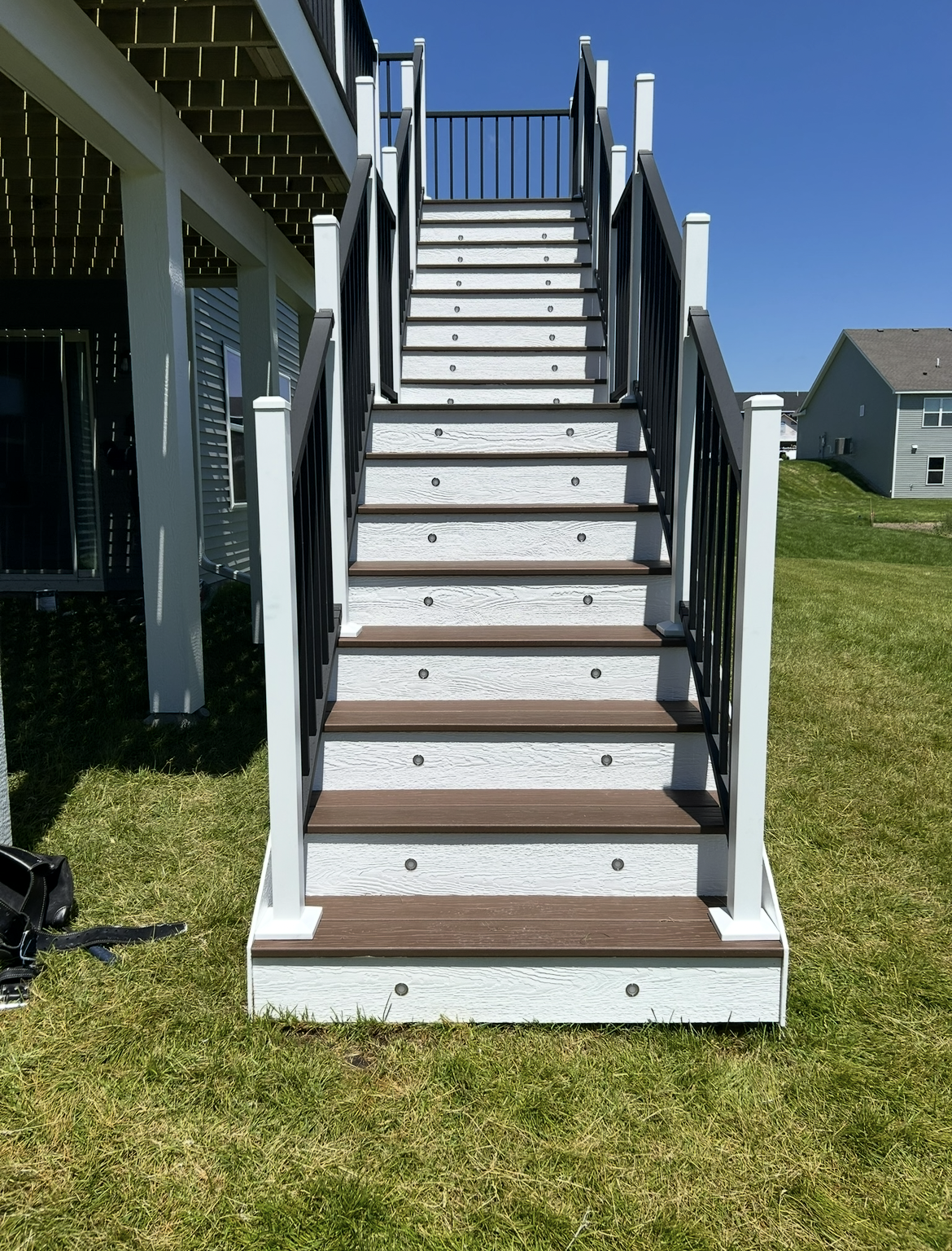 A set of stairs leading up to a deck with a black railing