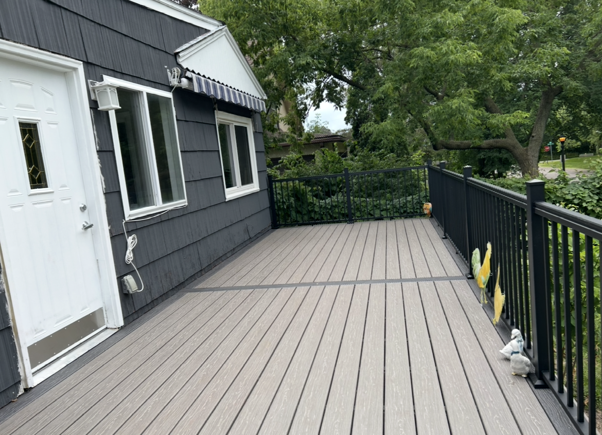 A house with a large deck and a black railing.