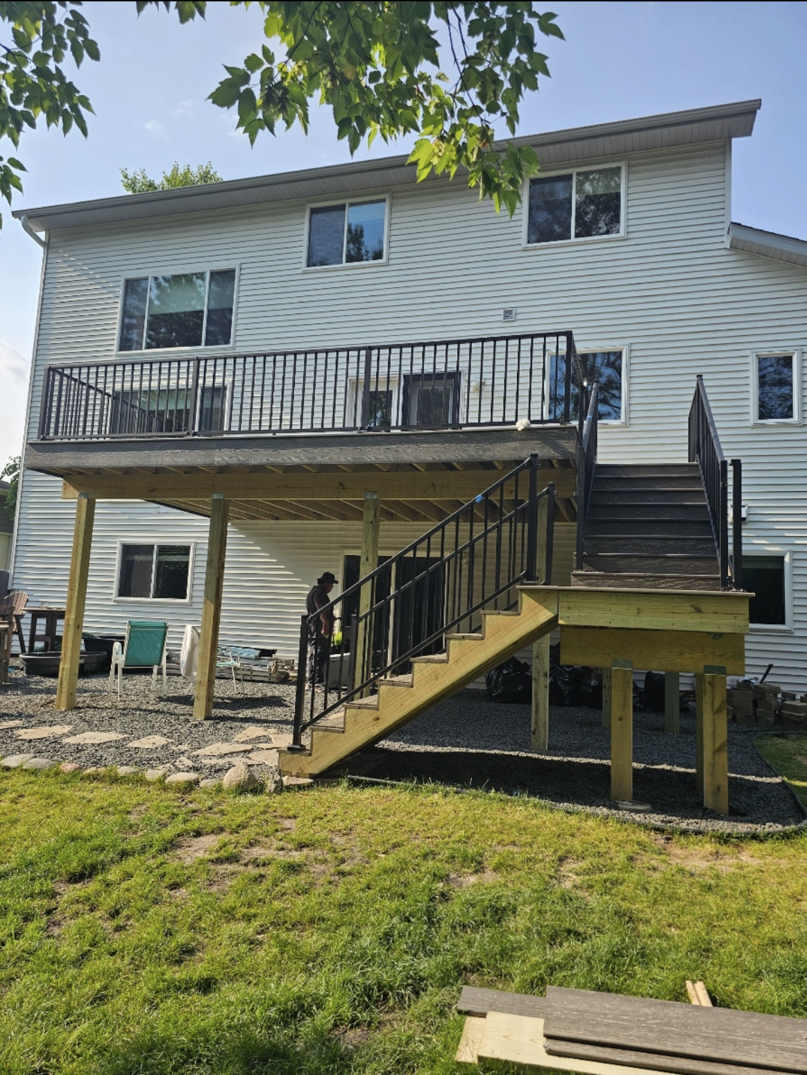A large white house with a wooden deck and stairs.