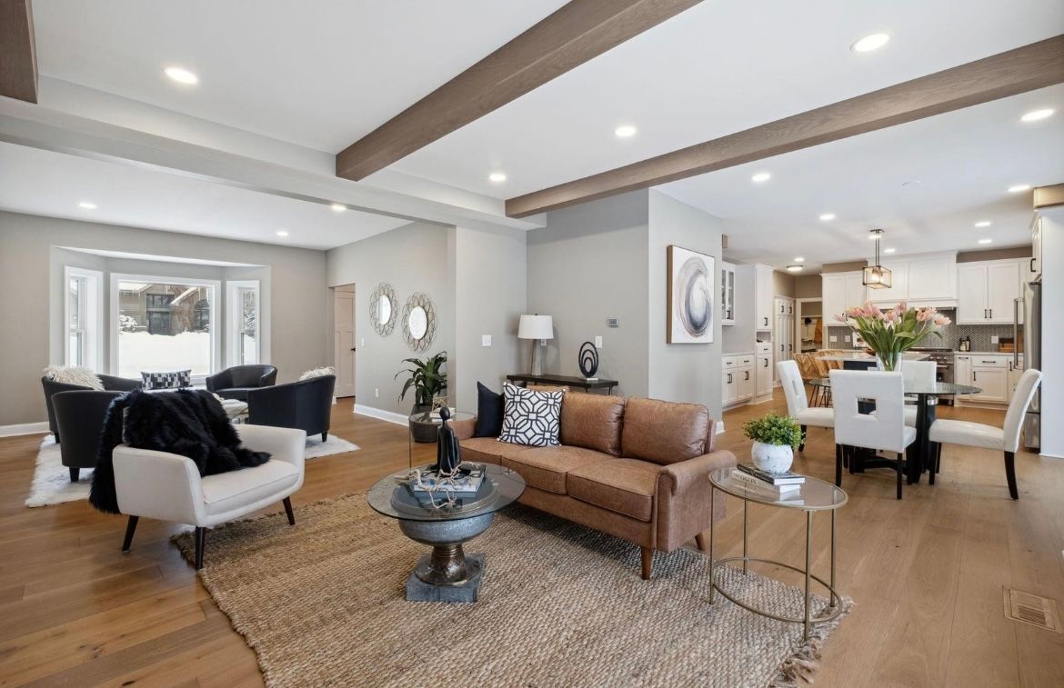 A living room with a couch , chairs , and a coffee table.