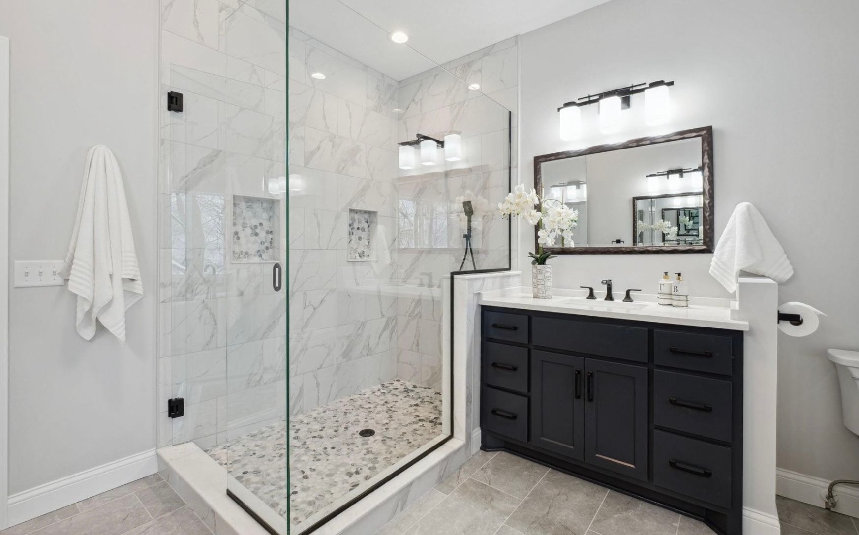 A bathroom with a walk in shower and two sinks.