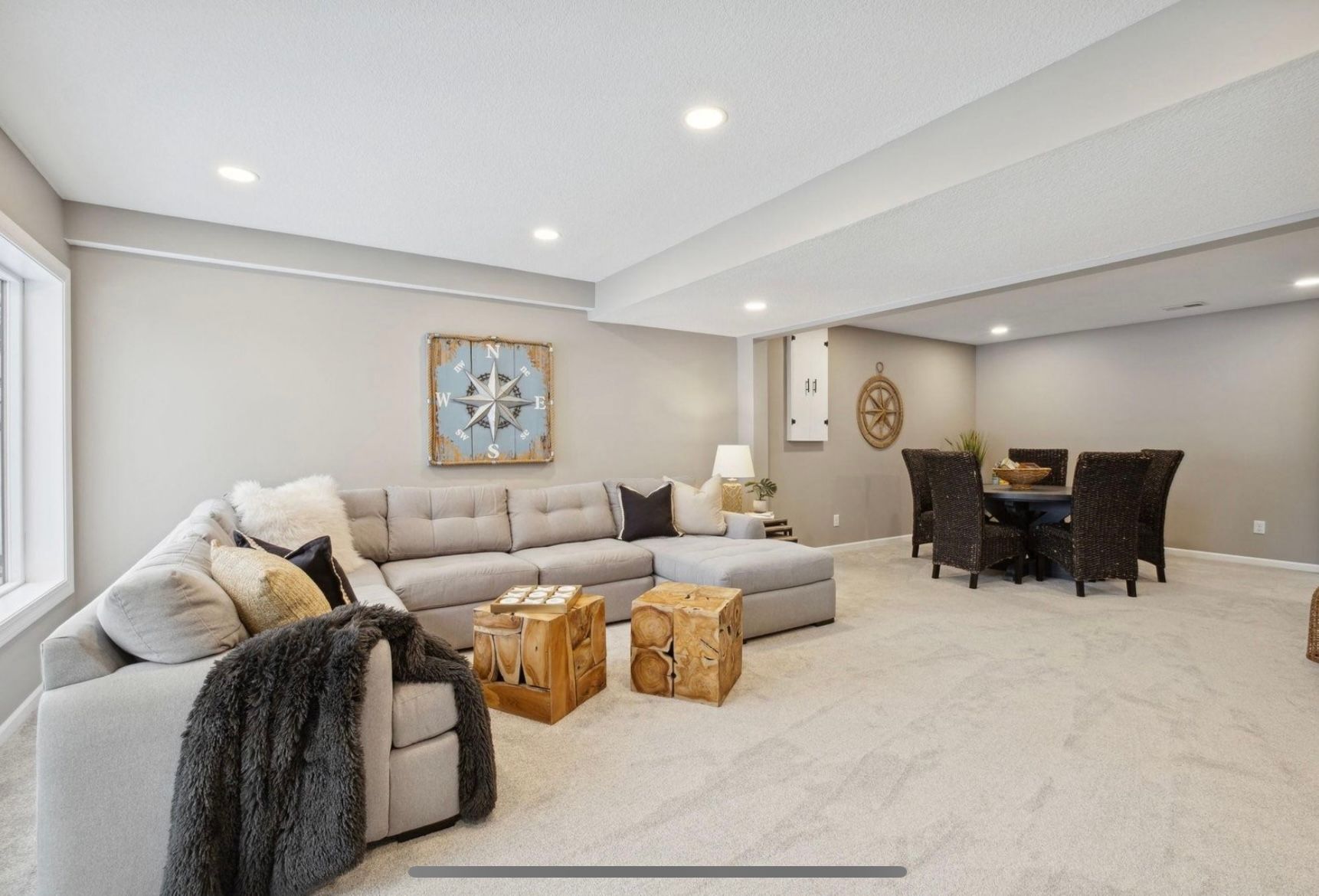 A living room with a large sectional couch and a dining room table.