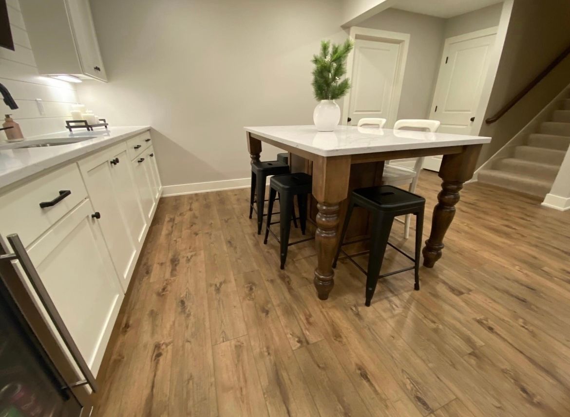 A kitchen with a table and stools in it.