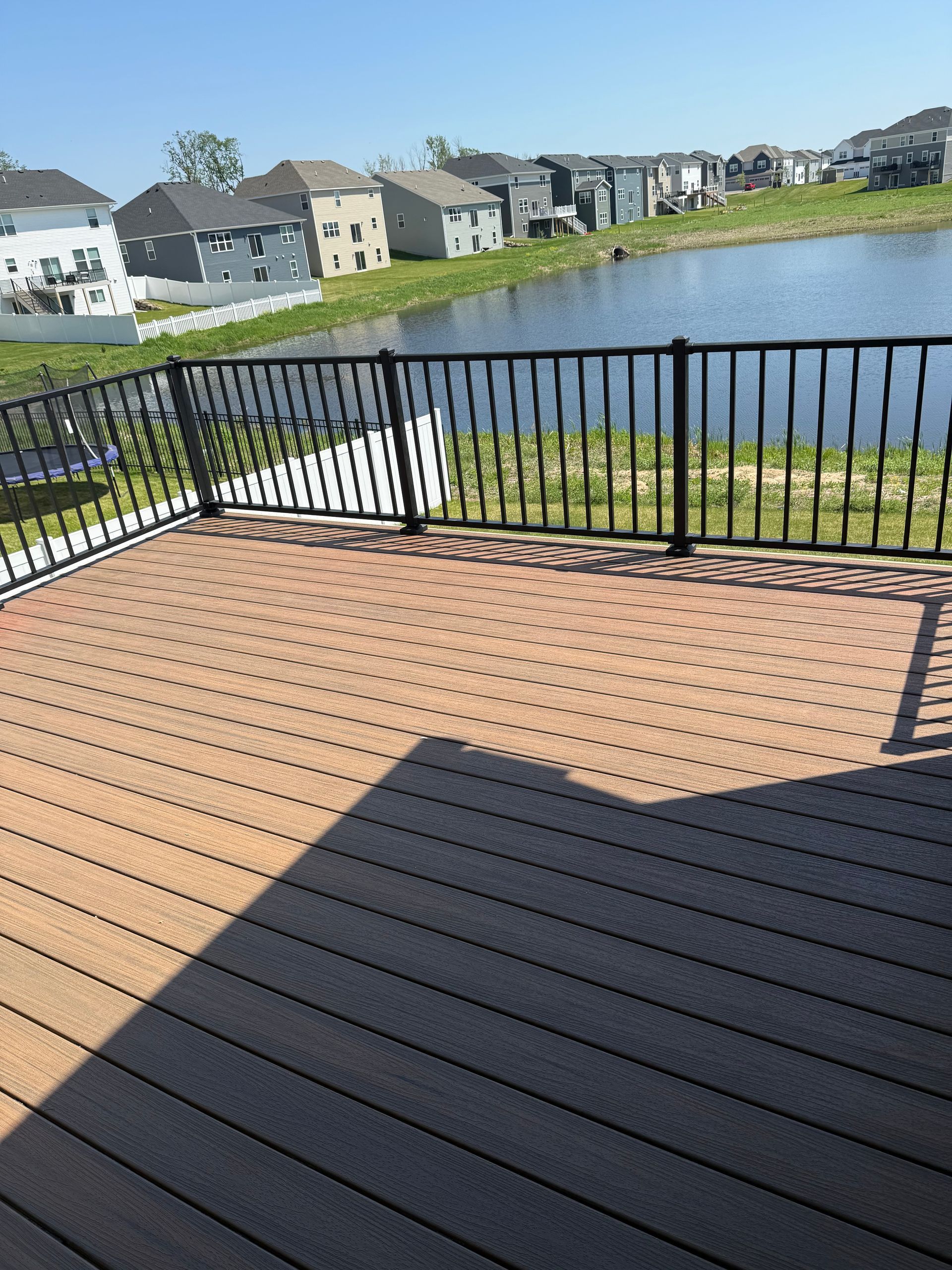 A deck with a railing overlooking a body of water