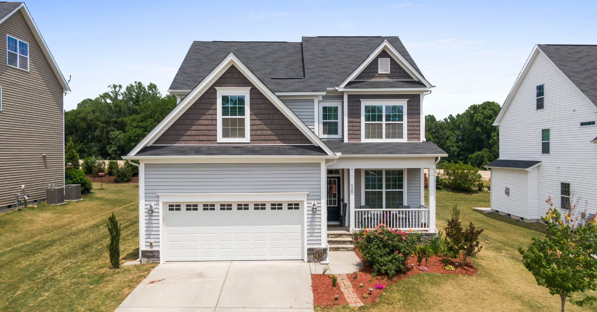 An aerial view of a house with a garage and a porch.