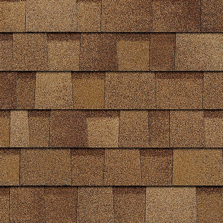 A close up of a roof with brown shingles.