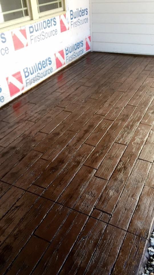 Freshly stained wooden porch deck beside house exterior wrapping under construction wrap