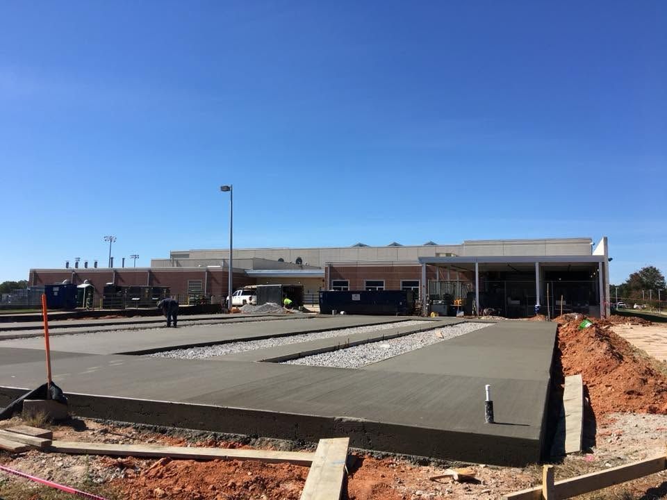 Newly paved parking lot in front of a low brick building under a clear blue sky