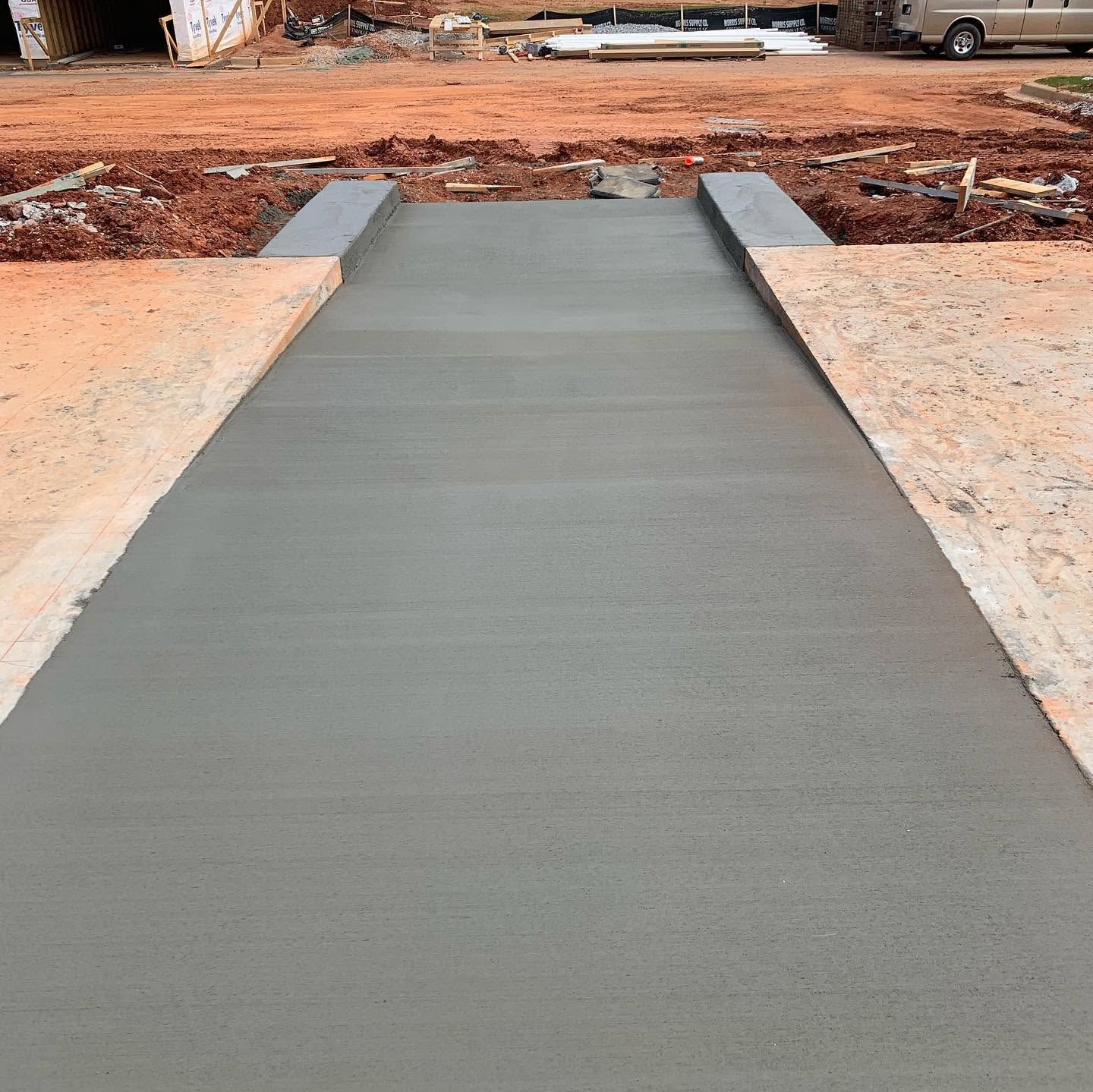 Fresh concrete walkway leading to a street in a construction area