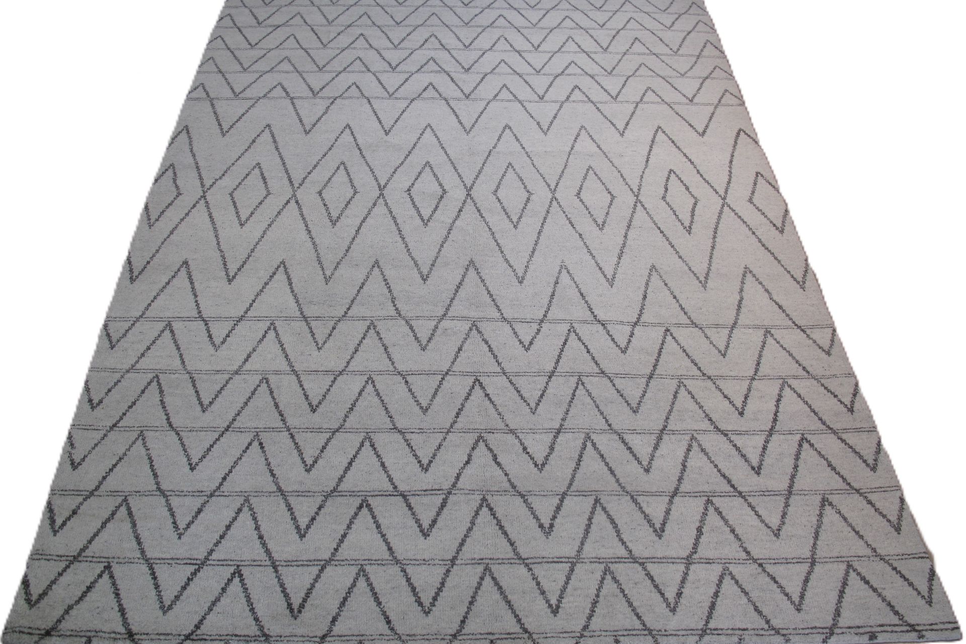 Gray rug with repeating diamond and zigzag pattern.