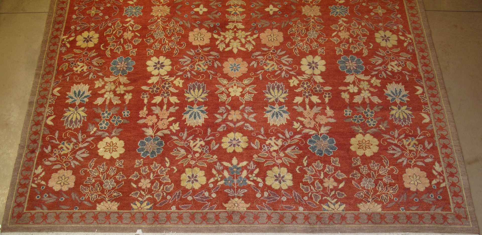 Red and gold oriental rug with floral pattern.