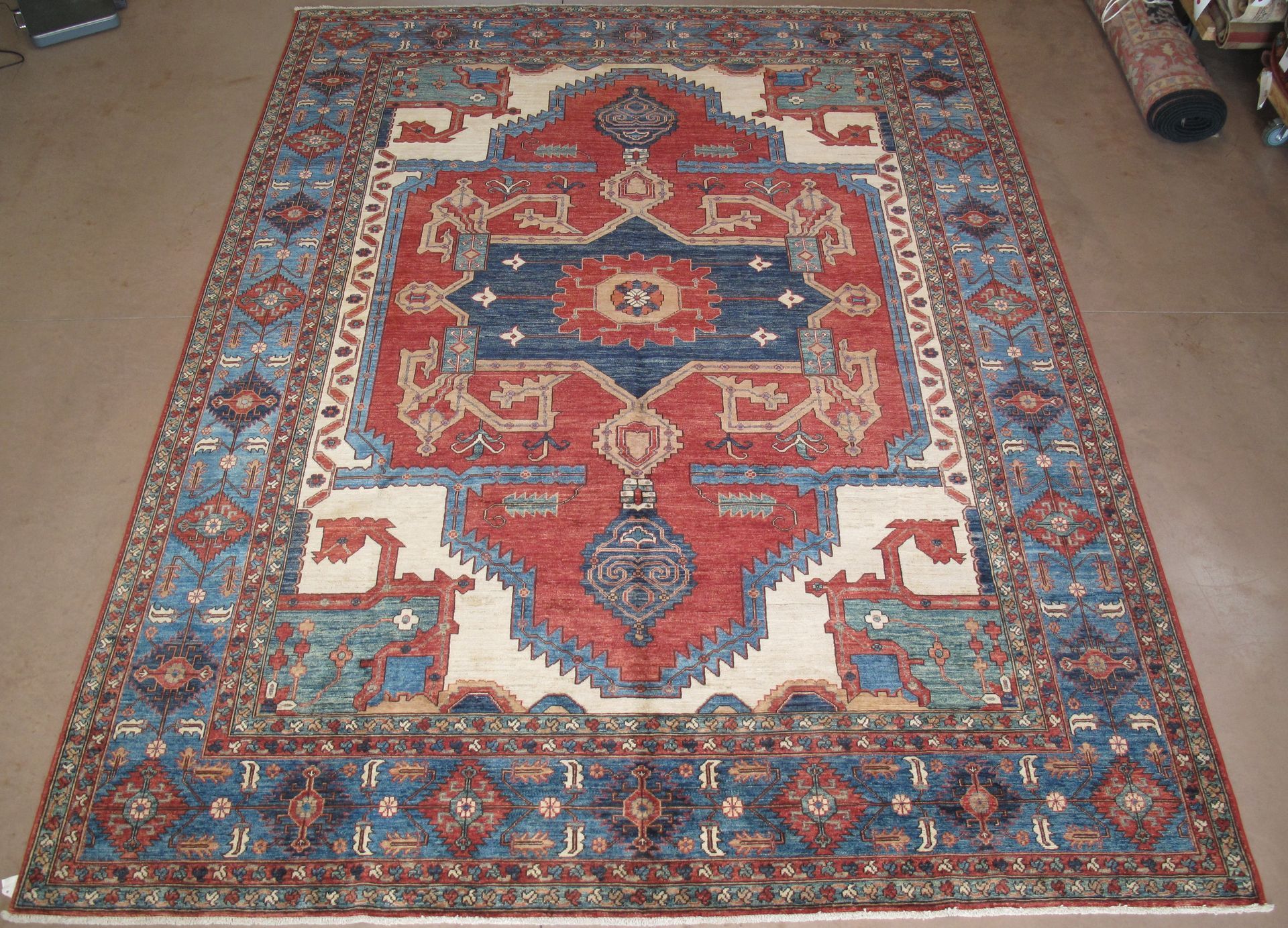 Oriental rug with a blue and red central design, surrounded by a blue border.