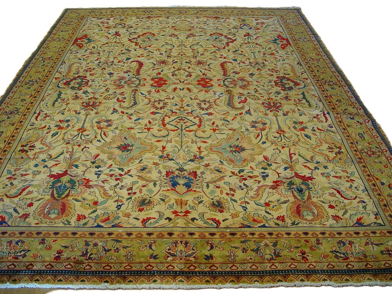Large ornate beige rug with floral patterns and a decorative border, shown flat against a white background