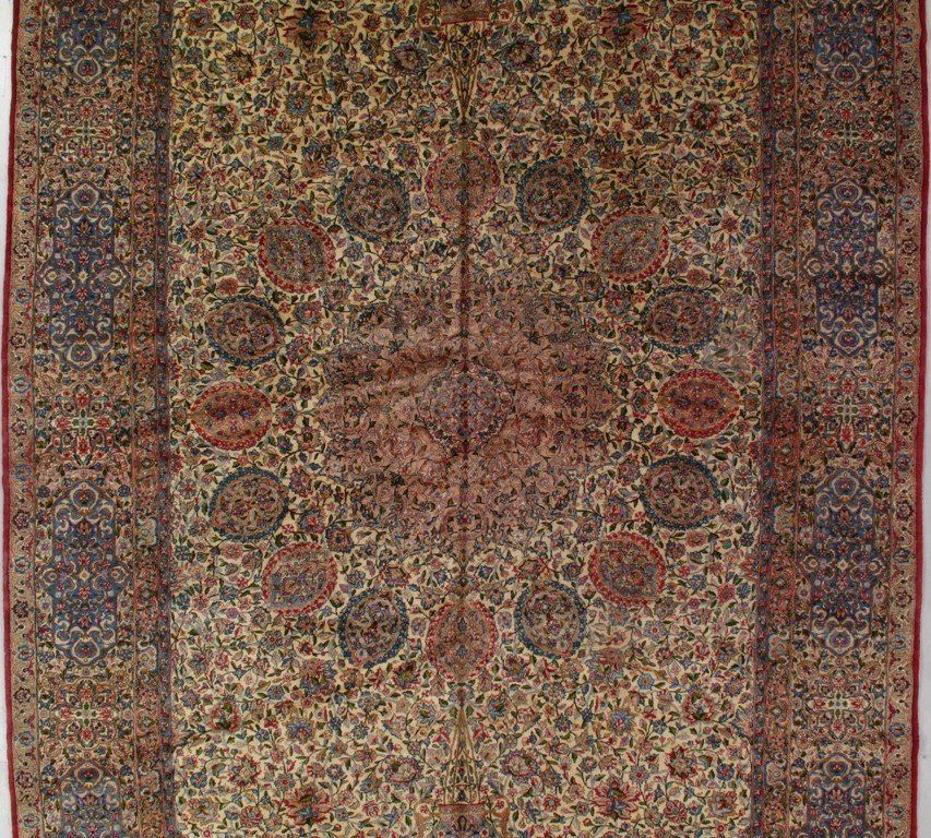 A rug with a floral pattern and a red border