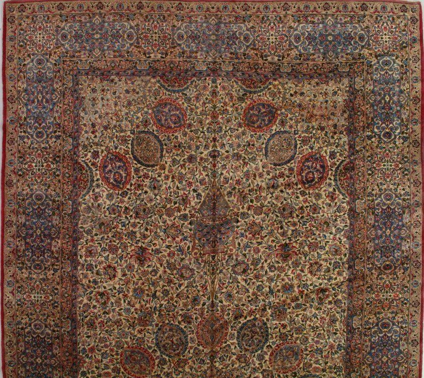 A rug with a floral pattern and a red border