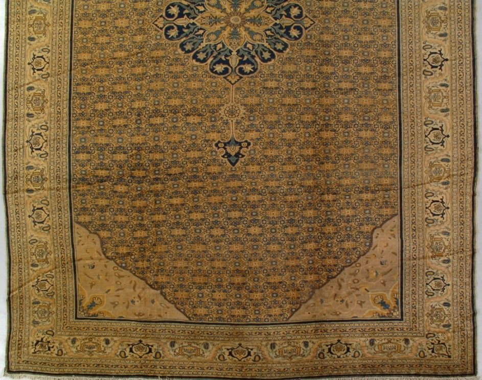Tan and navy prayer rug with ornate border and central floral design.