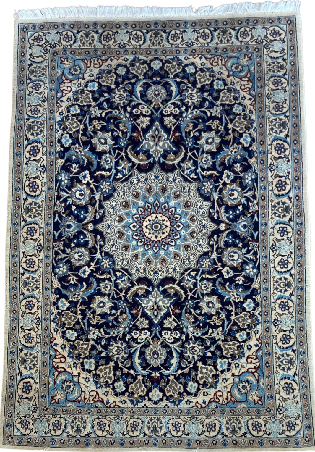 A blue and white rug with a floral pattern on a white background.
