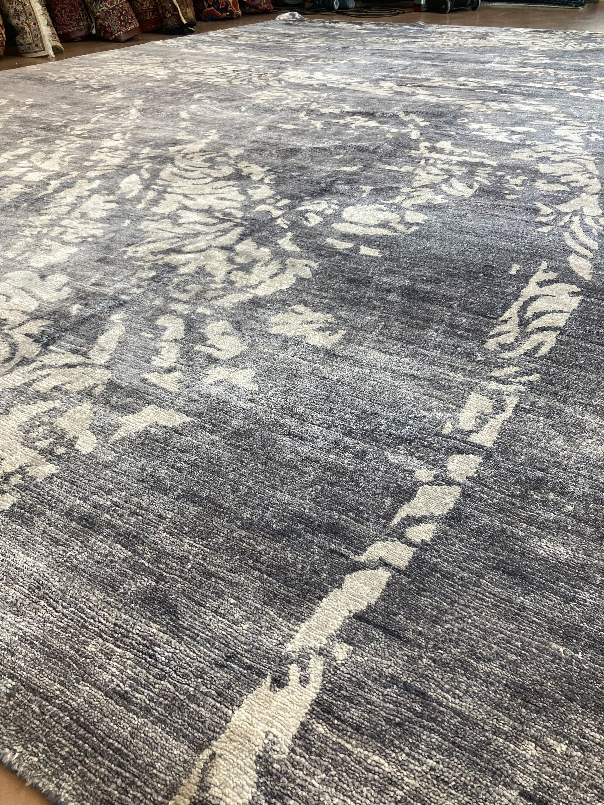 A gray and white rug is sitting on a wooden floor.