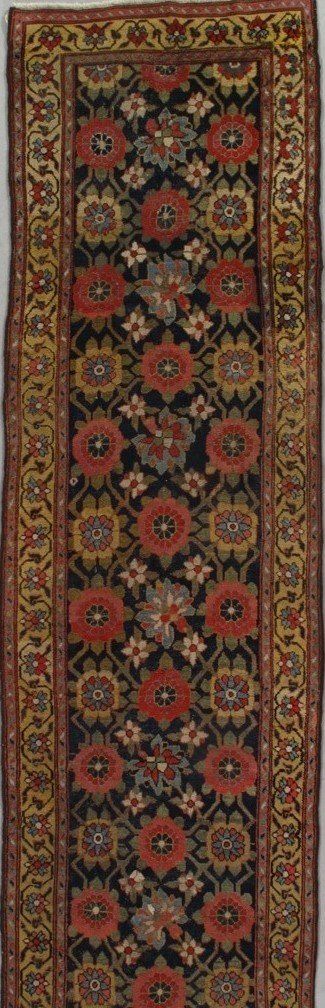 A rug with a floral pattern on it is hanging on a wall.