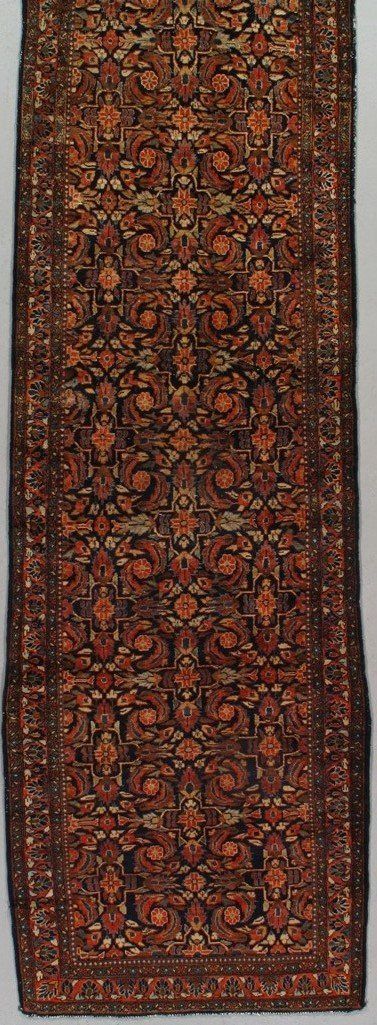 A rug with a floral pattern on it is hanging on a wall.