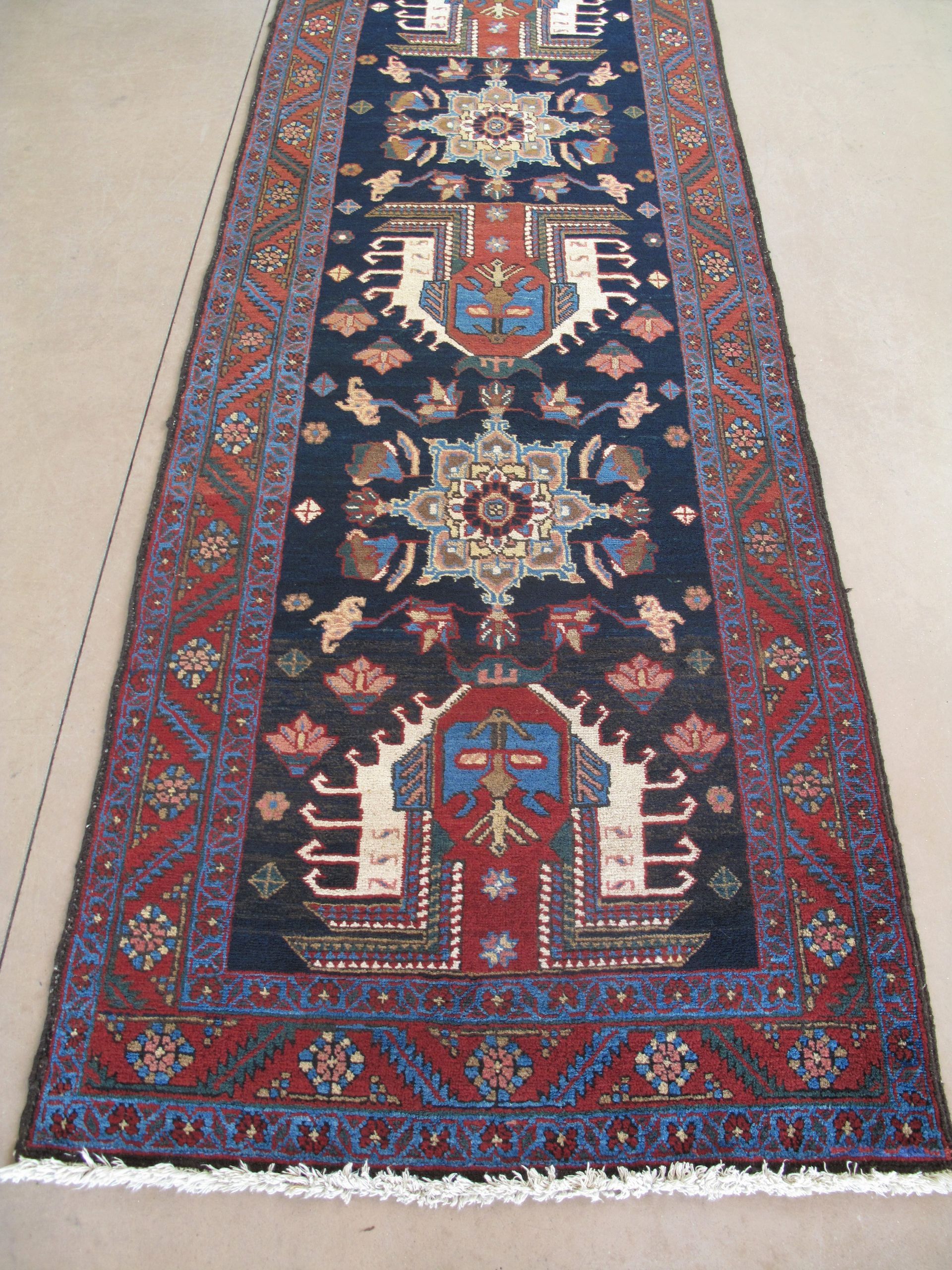 Dark blue runner rug with red and beige geometric patterns.