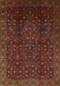 A red rug with a pattern on it is sitting on a white surface.