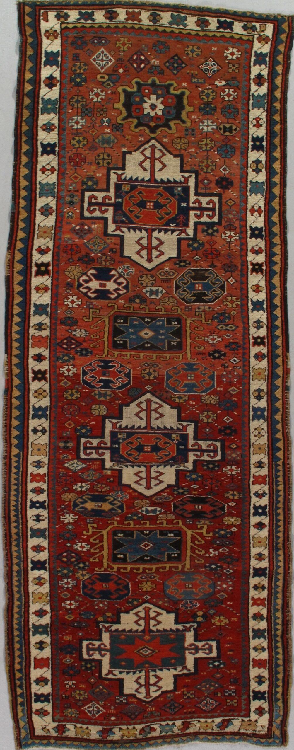 A rug with a pattern on it is hanging on a wall.