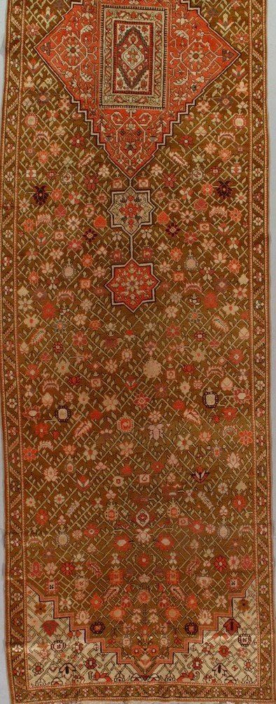 A rug with a floral pattern on it is hanging on a wall.