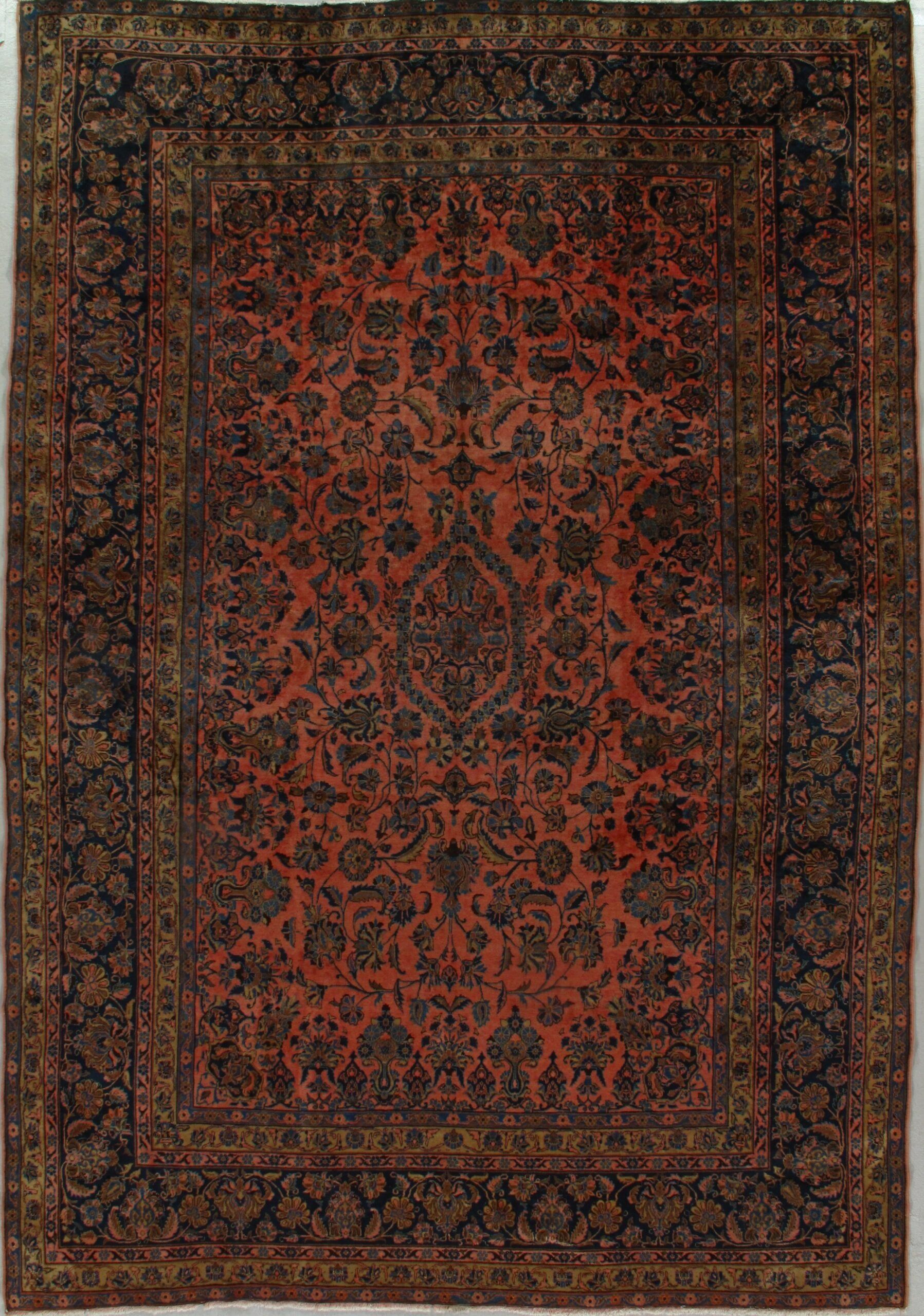 A rug with a floral pattern on it is hanging on a wall.