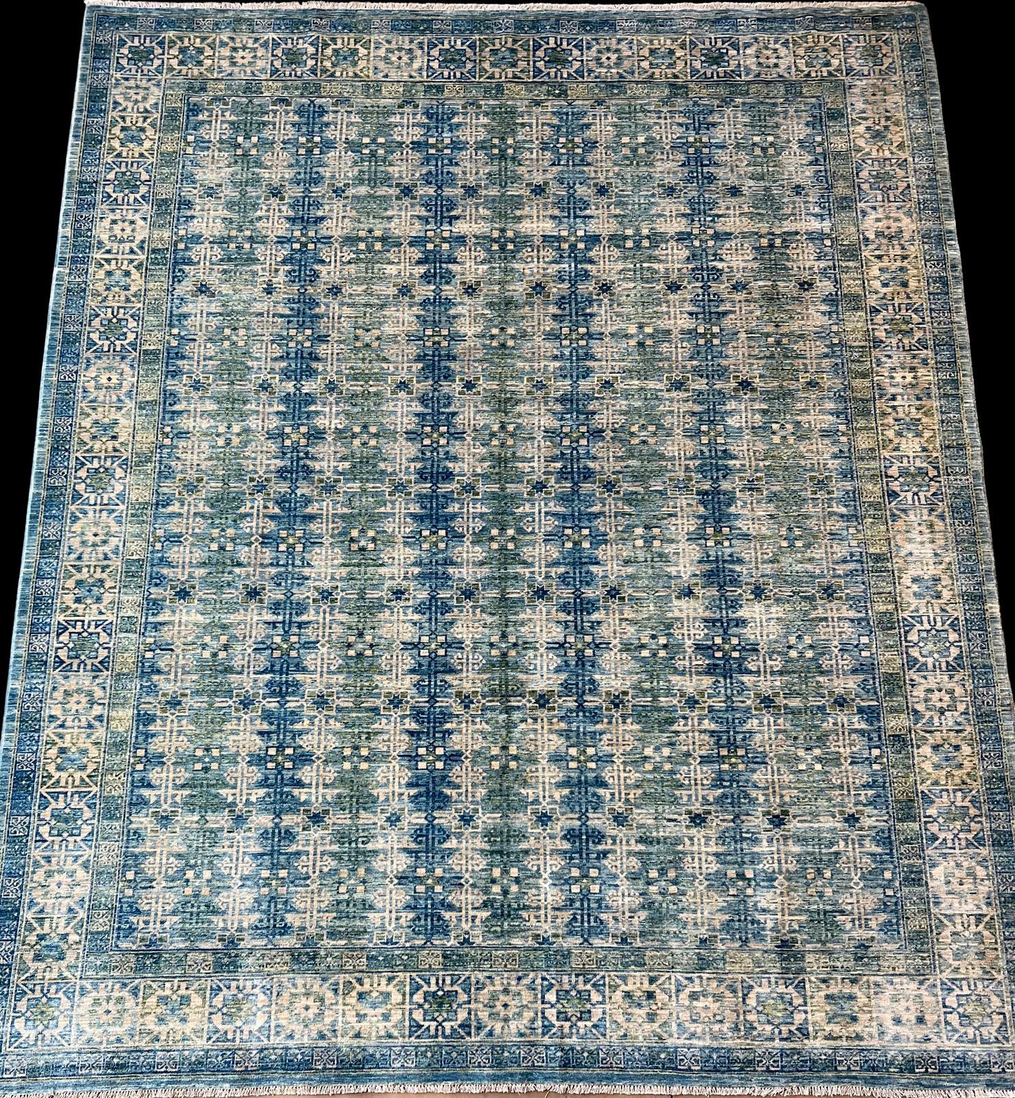 A blue and white rug with a pattern on it is on a black background.