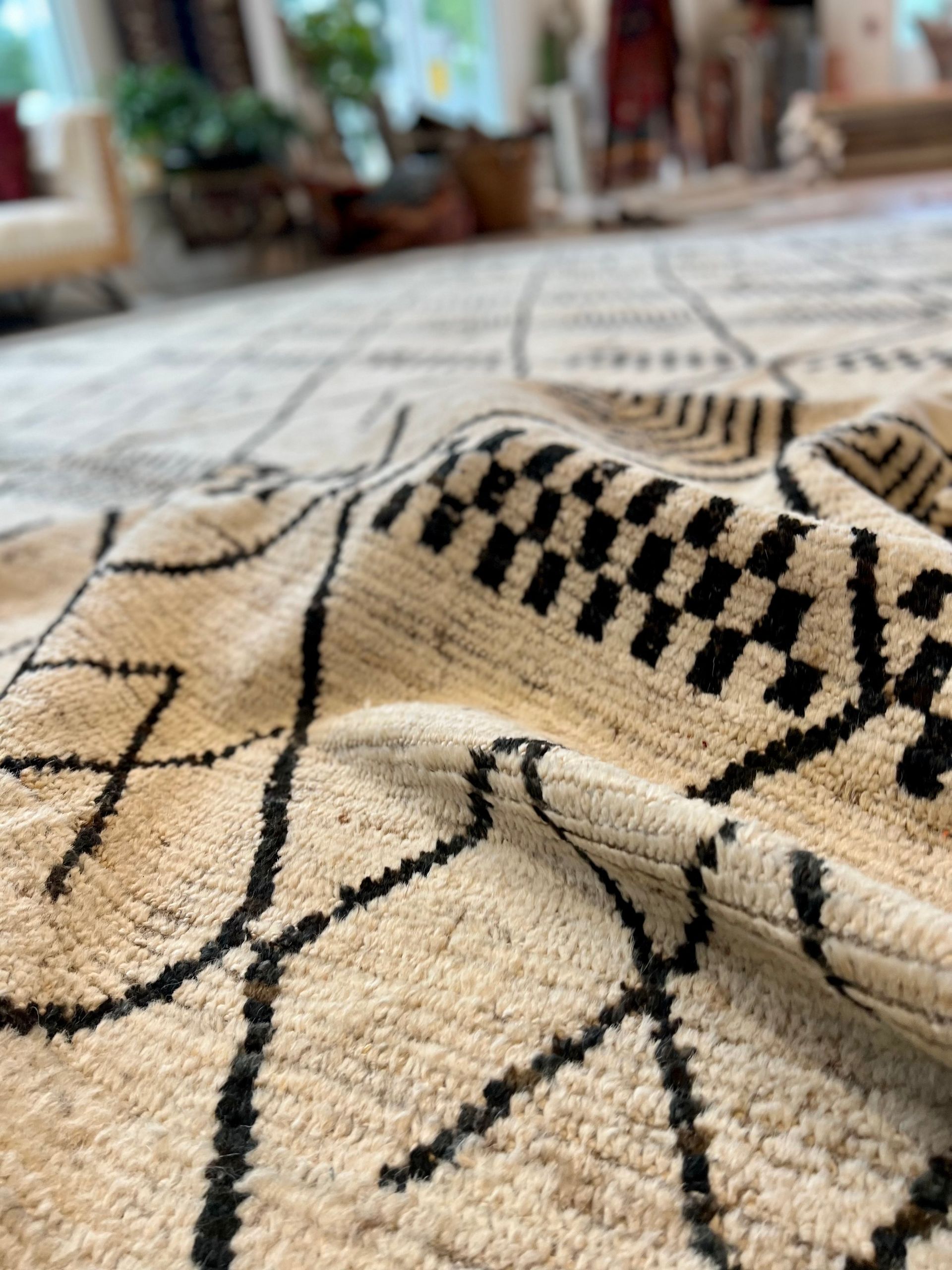 A rug with a black and white pattern on it is sitting on a wooden floor.