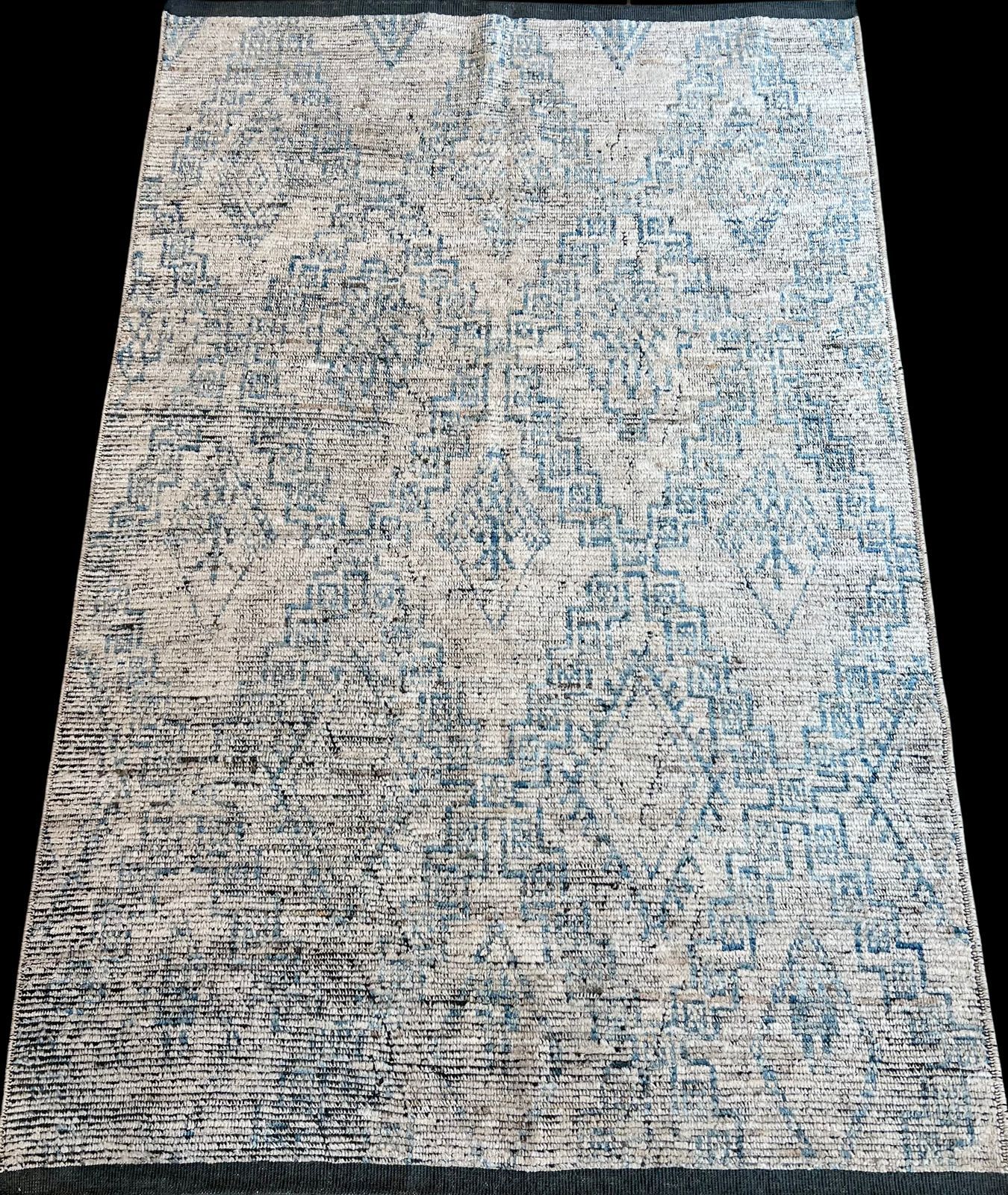 A rug with a pattern on it is sitting on a black surface.