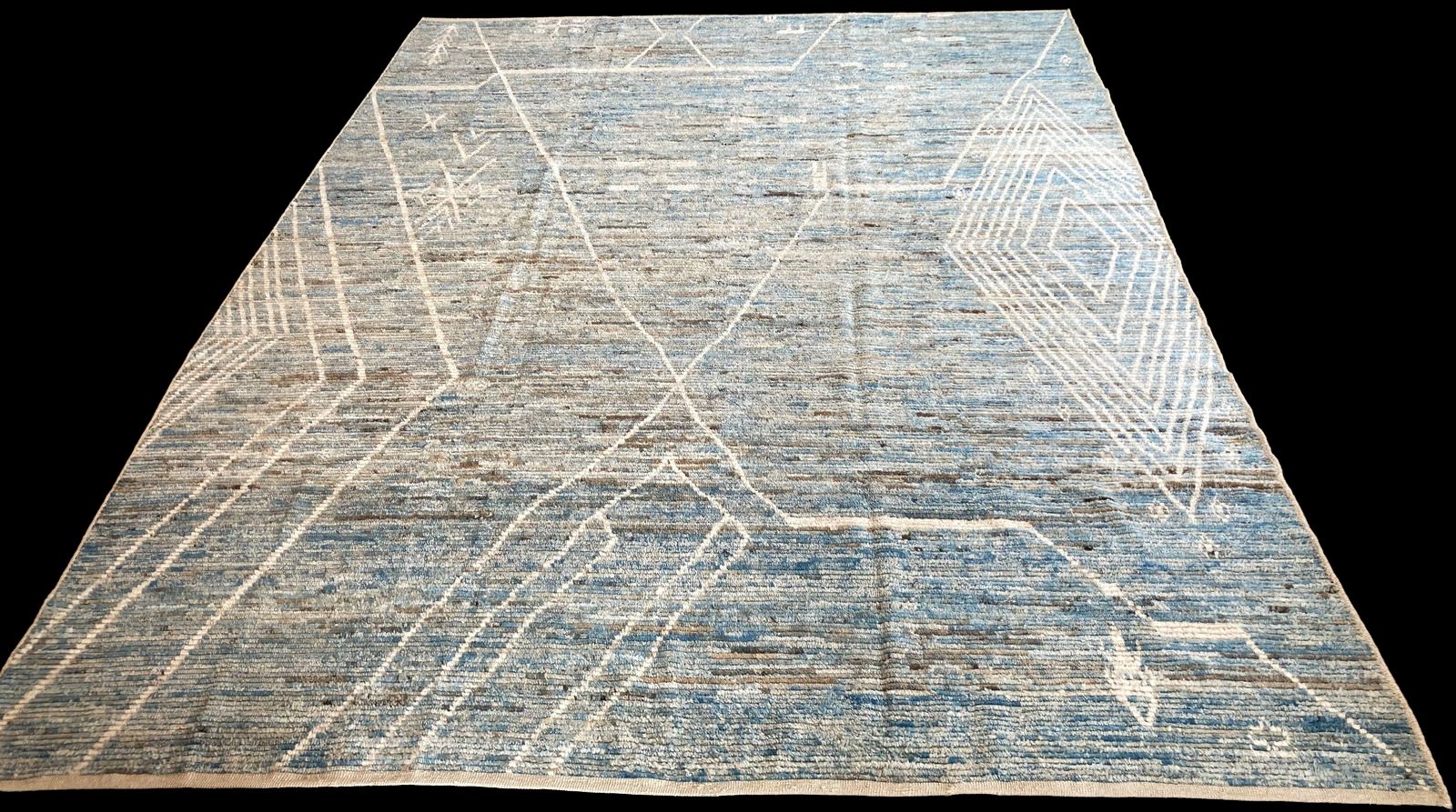 A blue and white rug is sitting on a black surface.